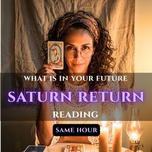 Könnte beinhalten: Eine Person mit lockigem Haar und Brille hält eine Tarotkarte mit einer Figur in einem Kranz. Der Text lautet: WHAT IS IN YOUR FUTURE SATURN RETURN READING SAME HOUR. Zwei Bienenwachskerzen und eine Öllampe stehen mit Tarotkarten auf dem Tisch.