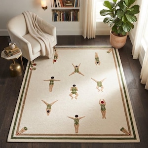 May include: A rectangular area rug with an off-white base and a dark green and tan border. The rug features a repeating pattern of figures wearing green swimsuits in various diving and swimming poses scattered across the center surface.