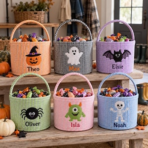 May include: Six cylindrical fabric baskets with handles, each featuring a gingham pattern and a unique Halloween-themed applique. The baskets are personalized with the names Theo, Max, Elsie, Oliver, Isla, and Noah, and are filled with assorted candies.