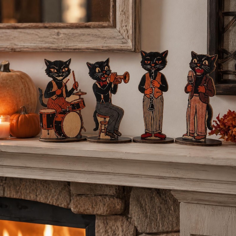 May include: A set of four flat wooden cutouts depicting black cats dressed in vintage clothing and playing musical instruments, including a drummer, a trumpet player, a clarinetist, and a singer standing at a microphone, all on circular bases.