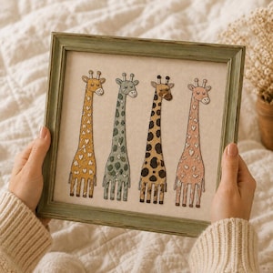 May include: A square wooden frame with a distressed green finish containing an illustration of four giraffes. The giraffes feature distinct patterns in yellow, sage green, brown, and pink, all set against a neutral beige background.