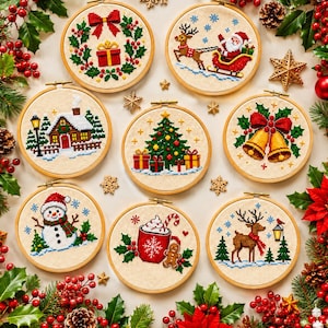May include: Eight circular wooden embroidery hoops featuring cross-stitch designs of Christmas themes including a wreath, Santa in a sleigh, a snowy cabin, a decorated tree, golden bells, a snowman, a mug of cocoa, and a reindeer.