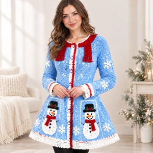 May include: A light blue crochet cardigan featuring a red collar with fringe, white snowflake appliques, and two large pockets each displaying a white snowman with a black hat and red scarf. The garment has a white scalloped hem and white buttons.