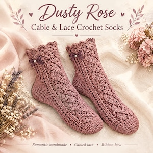 Puede incluir: Un par de calcetines de ganchillo color rosa polvoriento con un patrón de cable y encaje, un borde superior festoneado y un pequeño lazo de cinta marrón oscuro con una perla central. El texto dice Dusty Rose Cable & Lace Crochet Socks.