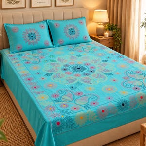 Peut inclure: Une parure de lit turquoise vif ornée d'un grand motif mandala central entouré de petites fleurs et de formes cachemire dans des tons rose, jaune et bleu foncé. L'ensemble comprend deux taies d'oreiller assorties avec un mandala centré.