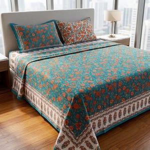 May include: A bedspread and two matching pillowcases featuring a teal background with an orange floral pattern. The bedding set includes a wide white border along the edges decorated with a repeating orange and brown botanical print design.