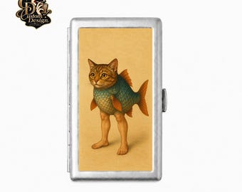Pode incluir: Uma cigarrilha retangular de metal prateado com uma ilustração central de uma criatura híbrida com cabeça de gato malhado castanho, corpo de peixe com escamas azuis e pernas humanas sobre um fundo bege claro.