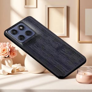May include: A dark blue smartphone case with a textured, wood-grain-like finish and a rectangular camera module featuring three circular lenses. The word Aioria is embossed vertically on the right side of the back panel of the phone case.