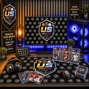 Op de afbeelding: Een gaming-opstelling met een computermonitor, een bureau-mat en een koptelefoon, allemaal voorzien van het US Sports Breaks-logo. Drie gegradeerde sportkaarten in doorzichtige hoesjes naast een stapel kaarten en een computermuis.