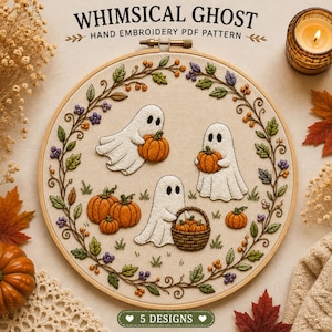 May include: A round wooden embroidery hoop containing a hand-stitched fabric panel with the text WHIMSICAL GHOST HAND EMBROIDERY PDF PATTERN and 5 DESIGNS. The design features three white ghosts, orange pumpkins, and a circular vine border.