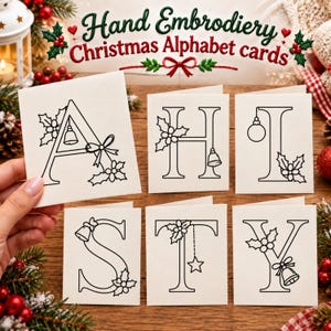 Puede incluir: Seis tarjetas de felicitación blancas plegadas con dibujos de líneas negras de las letras A, H, I, S, T e Y decoradas con motivos navideños como acebo, campanas y adornos. El texto Hand Embroidery Christmas Alphabet cards es visible arriba.