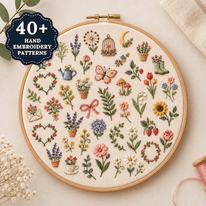 May include: A round wooden embroidery hoop containing off-white fabric with 40+ hand embroidery patterns featuring colorful flowers, a butterfly, mushrooms, a birdcage, a watering can, and hearts. A dark blue badge reads 40+ HAND EMBROIDERY PATTERNS.