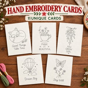 Puede incluir: Un conjunto de cinco tarjetas rectangulares blancas con patrones de bordado en puntos negros de un zorro, una taza de té con flores, un ramo floral, un globo aerostático y una mariposa. El texto dice Good Things Take Time, Make It Beautiful, You Grow Girl, Dream Big y Stay Wild.
