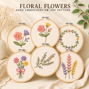 May include: Six circular wooden embroidery hoops containing white fabric with various floral designs. The text at the top reads FLORAL FLOWERS HAND EMBROIDERY|18| PDF PATTERN. The designs feature pink, yellow, purple, and green thread.