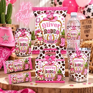 Könnte beinhalten: Ein Set mit Partyartikeln im Rodeo-Thema mit rosa Cowgirl-Hüten, braunen Kuhfleckenmustern und dem Text Oliver Rodeo 1 Yeehaw. Das Set enthält eine Chipstüte, eine Wasserflasche, einen Saftbeutel, zwei Riegel und eine Geschenkbox.