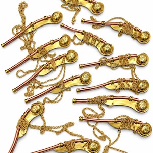 Pu&ograve; includere: Una collezione di dieci fischietti in metallo, ognuno caratterizzato da un tubo color rame e un corpo curvo color oro. Ogni fischietto include una catenella dorata e un'estremit&agrave; circolare con impresso un simbolo di ancora, disposti sparsi.