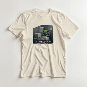 Op de afbeelding: Een crèmekleurig T-shirt met korte mouwen en een afbeelding van een groen insect in een pak dat aan een bureau met een computer werkt, een klok aan de muur en de tekst "Corporate Life Of An Insect" in het wit onderaan de afbeelding.