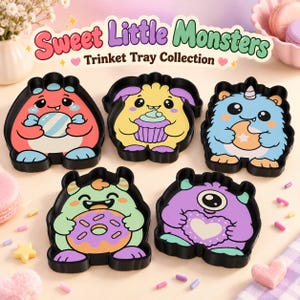 Może przedstawiać: Pięć czarnych tacek na drobiazgi z kolorowymi ilustracjami potworów. Tekst "Sweet Little Monsters Trinket Tray Collection" znajduje się nad tackami, które przedstawiają czerwonego, żółtego, niebieskiego, zielonego i fioletowego potwora.