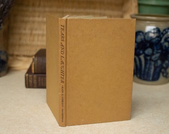 May include: A brown hardcover book with the title "Tears and Laughter" by Kahlil Gibran printed on the spine.