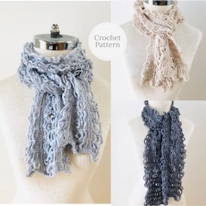 May include: Three crocheted scarves in different colours: light grey, beige, and dark grey. The scarves are made with a lacy stitch and have a ruffled edge. The scarves are displayed on mannequins. Crochet Pattern.