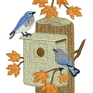 May include: An embroidery design featuring a light-colored wooden birdhouse mounted on a textured brown tree trunk. Two blue and white birds are perched on the structure, surrounded by orange maple leaves on thin brown branches.