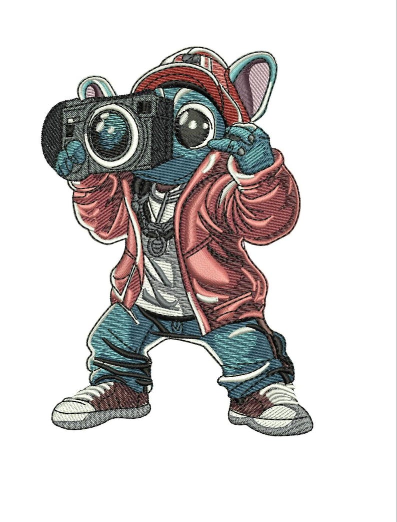 May include: An embroidered patch featuring a blue cartoon character wearing a red baseball cap, a red jacket, and blue jeans. The character is holding a black camera up to its face with both hands and wearing white sneakers with brown accents.