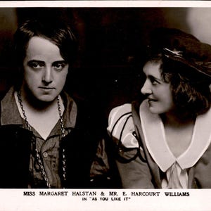 Puede incluir: Una fotografía antigua en tono sepia que muestra a dos personas con trajes teatrales. El texto en la parte inferior dice: PERCY GUTTENBERG COPYRIGHT, MISS MARGARET HALSTAN & MR. E. HARCOURT WILLIAMS IN "AS YOU LIKE IT", MANCHESTER 531.