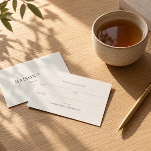 Puede incluir: Dos tarjetas de cita de color blanco roto con texto en negro. Una tarjeta muestra MAISON VERA, mientras que la otra presenta campos para DATE, TIME y SERVICE, con el texto See you at your next visit y MAISON VERA +1 604 555 0119.