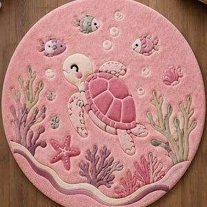 May include: A round, pink area rug featuring a raised, textured design of a sea turtle swimming among coral, starfish, and small fish. The rug includes various shades of pink, green, and purple, with circular bubbles floating above the turtle.