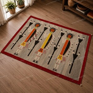 May include: A rectangular area rug featuring a gray background with three stylized figures in orange, yellow, and orange, accented by black geometric shapes and a solid red border. The design includes intricate line work and small red details.