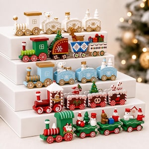 May include: Five wooden toy trains arranged on white tiers. Each train features colorful painted details including snowmen, reindeer, Christmas trees, presents, and gingerbread figures. The trains have wheels and various festive patterns like snowflakes and stripes.