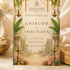 May include: A rectangular wedding invitation card featuring a central illustration of a temple entrance with banana leaves, hanging oil lamps, and lotus flowers. The text reads: The Iyer and Sarma families cordially request your presence at the HINDU MARRIAGE of ANIRUDH & SHRINAYA, 23 | Nov | 2026, SIDDHI VINAYAKA HALL, Muhurtham: 11:30am.