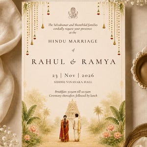 May include: A rectangular wedding invitation card featuring a cream background with hanging gold bells and floral garlands. It displays the text Hindu Marriage of Rahul and Ramya, dated 23 Nov 2026, at Siddhi Vinayaka Hall, with an illustration of a couple.