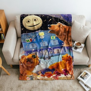 Pode incluir: Uma manta macia com uma cena noturna caprichosa, apresentando uma grande lua sorridente, uma casa azul e dois ursos castanhos. A casa está decorada com blocos de letras que formam a palavra HOME. O design inclui estrelas e um céu roxo.