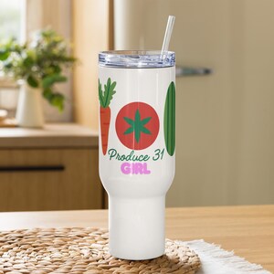 May include: A white stainless steel tumbler with a clear lid and a straw. The design features a carrot, a red tomato, and a green cucumber. Below the vegetables, the text reads Produce 31 in green script and GIRL in bold pink letters.