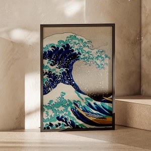 May include: A framed wall art print featuring a stylized depiction of a large ocean wave in shades of deep blue, teal, and white, with a small yellow boat visible at the base of the cresting water against a neutral background.