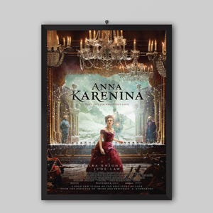 Op de afbeelding: Een ingelijste filmposter voor Anna Karenina met een centrale figuur in een donkerrode jurk voor een podium met kroonluchters. De tekst luidt Anna Karenina, You can't ask why about love, Keira Knightley, Jude Law en November 2012.