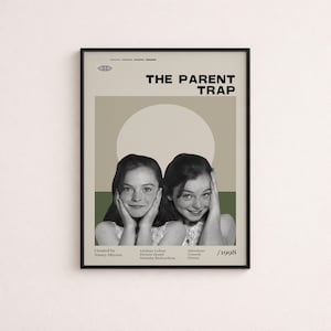 Può includere: Un poster incorniciato del film The Parent Trap del 1998 con una fotografia in bianco e nero di due ragazze identiche con le mani vicino al viso, su uno sfondo beige e verde oliva con testo che include il cast e la troupe del film.