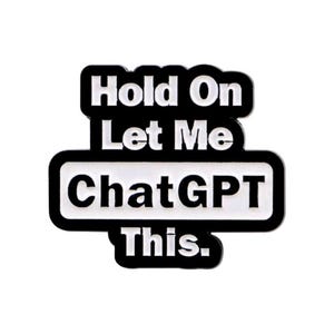 May include: A black and white pin with the text "Hold On Let Me ChatGPT This." The text is in a bold, sans-serif font. The pin has a rounded rectangular shape.
