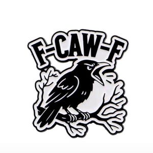 May include: A black and white enamel pin featuring a black crow perched on a branch. The crow is screaming with its beak open. The pin has the text "F-CAW-F" in a stylized font.