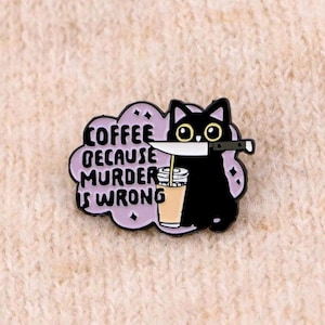 Może przedstawiać: Czarny kot emaliowany z nożem, filiżanką kawy i napisem "COFFEE BECAUSE MURDER IS WRONG" w fioletowej chmurze. Przypinka jest umieszczona na jasnobeżowym tle z tkaniny.