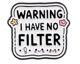 May include: A white enamel pin with a black border and the words "WARNING I HAVE NO FILTER" in bold black letters. The pin features a yellow star and a pink star with a smiling face. Additional small, smiling faces are at the bottom.