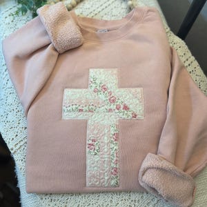 May include: A white ceramic mug with a black handle and the text "But First, Coffee" in a handwritten style. The mug is on a white surface. The mug is approximately 10 cm tall.