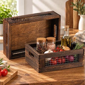 Könnte beinhalten: Zwei dunkelbraune Holzkisten mit Drahtgitterseiten und Griffaussparungen. Eine Kiste steht aufrecht, die andere enthält Gewürzgläser, eine Ölflasche, eine Essigflasche, rote Tomaten, eine rote Zwiebel und eine Knoblauchknolle.