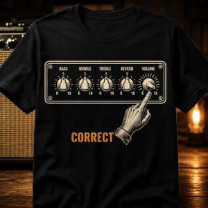 May include: A black t-shirt featuring a graphic of an amplifier control panel with knobs labeled Bass, Middle, Treble, Reverb, and Volume. A hand is shown pointing to the Volume knob, which is set to 10. The word CORRECT is printed in orange below.