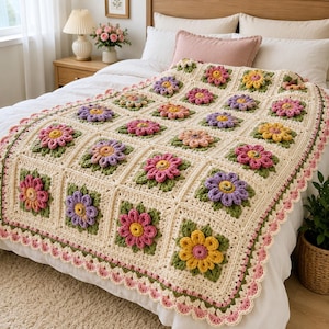 Puede incluir: Una manta de ganchillo hecha a mano con un patrón repetitivo de motivos cuadrados, cada uno con una flor tridimensional en tonos rosa, amarillo, morado y naranja, rodeada de hojas verdes y un borde color crema con acabado festoneado.