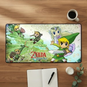 May include: A rectangular desk mat featuring The Legend of Zelda: The Minish Cap artwork with multiple illustrations of Link in green tunics and Princess Zelda against a light green forest background, with the game title printed in red and blue.