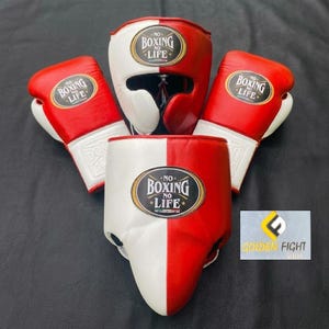 May include: A set of red and white boxing equipment including two boxing gloves and two head guards. Each piece features a black oval patch with the text NO BOXING NO LIFE in white lettering. The items are arranged together on a dark surface.