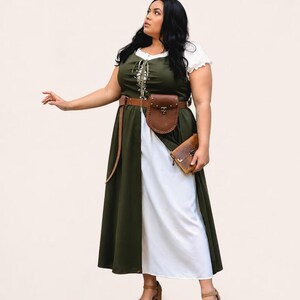 A plus-size model wearing a green and white medieval dress with a brown leather belt bag.