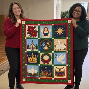 Könnte beinhalten: Ein rechteckiger Weihnachts-Quilt mit zwölf verschiedenen quadratischen Feldern. Die Motive zeigen Weihnachtssterne, einen Engel, einen Stern, eine Kirche, eine Krippenszene, ein Lamm, eine Krone, einen Kranz, eine Taube, Kerzen, die drei Weisen und eine Trommel.